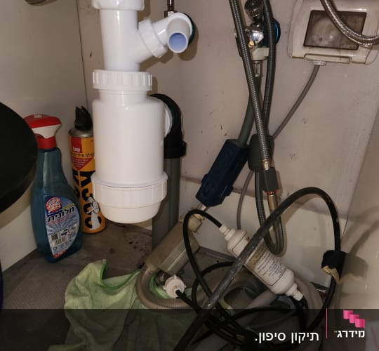 צנרת מתחת לכיור עם מסנן מים וצינורות